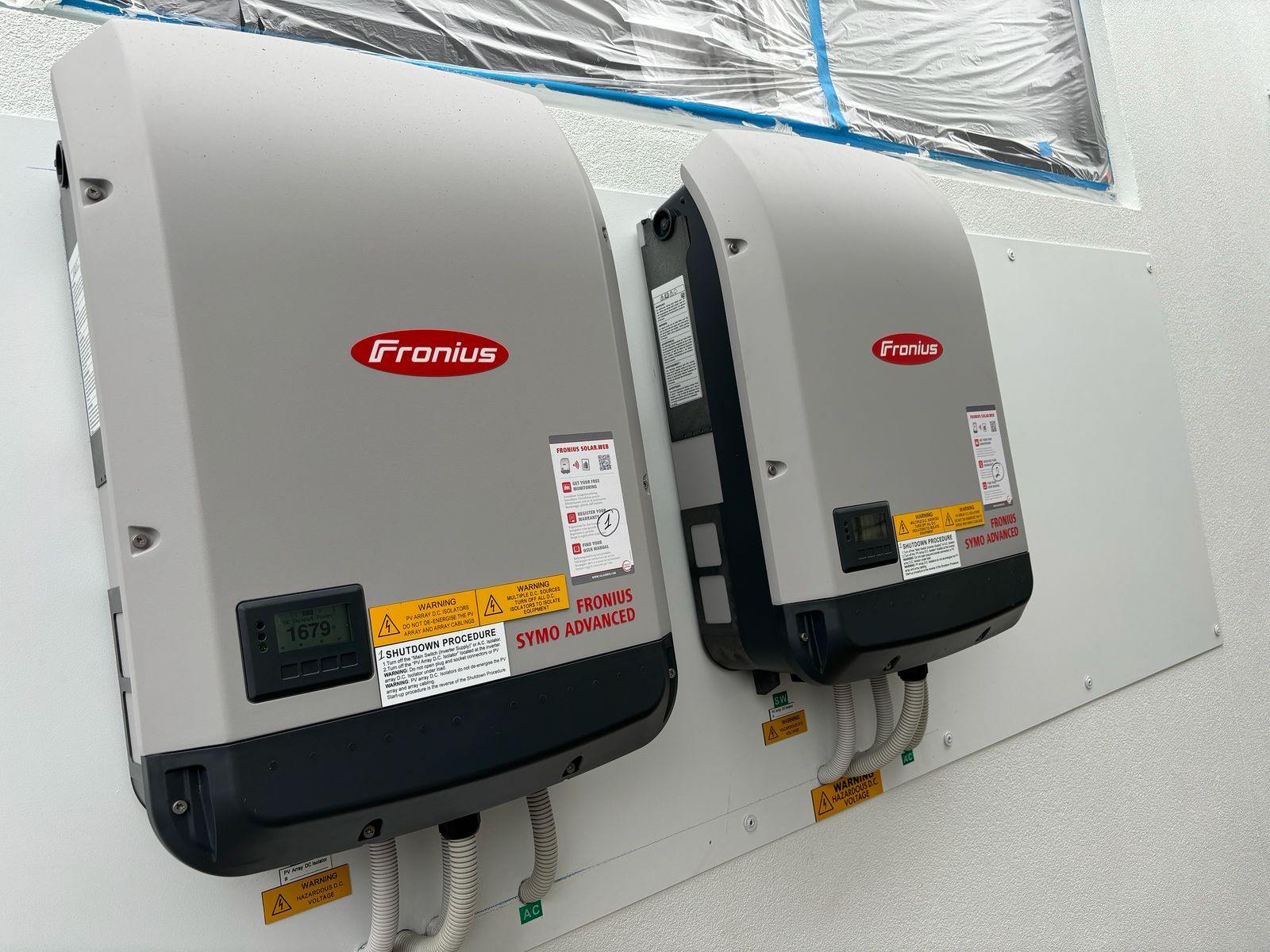 Two stacked Sungrow battery modules and inverter installed on the side of a Sydney home by Sinvesta Group.