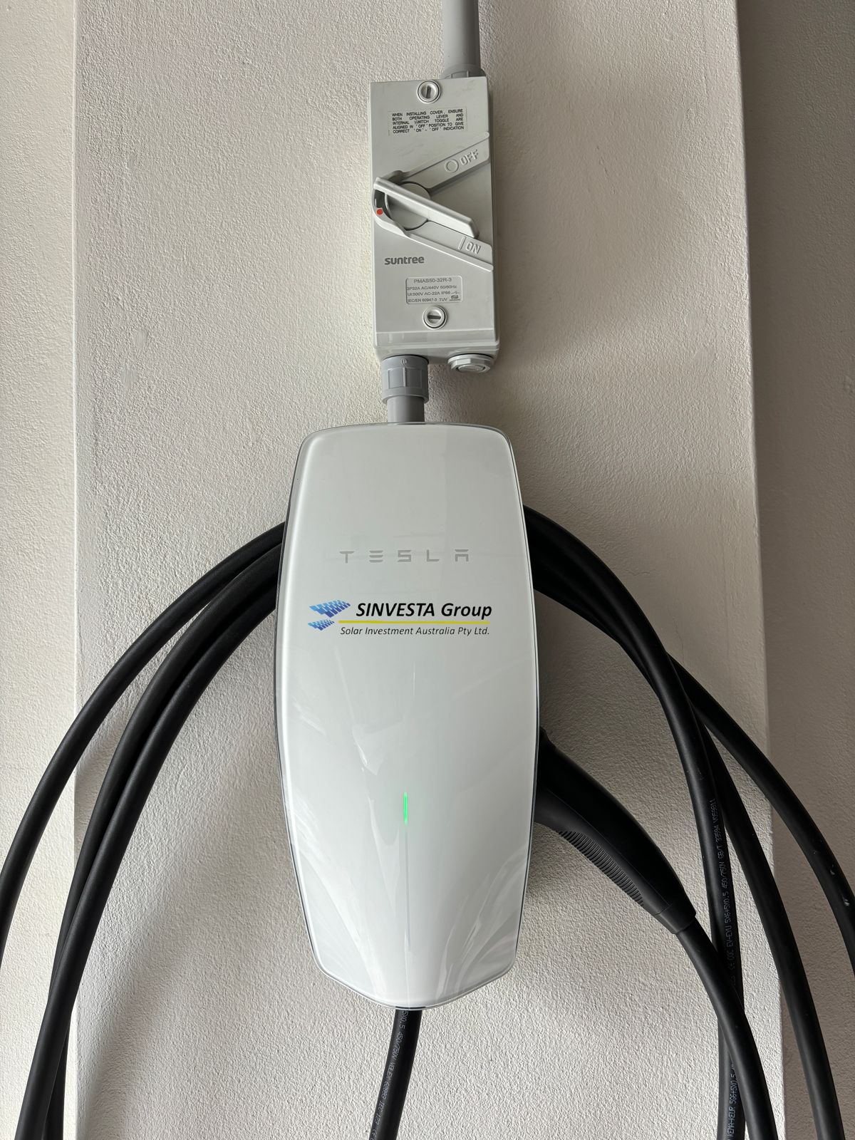 Tesla Wall Connector installed and branded by Sinvesta Group in a Sydney garage.