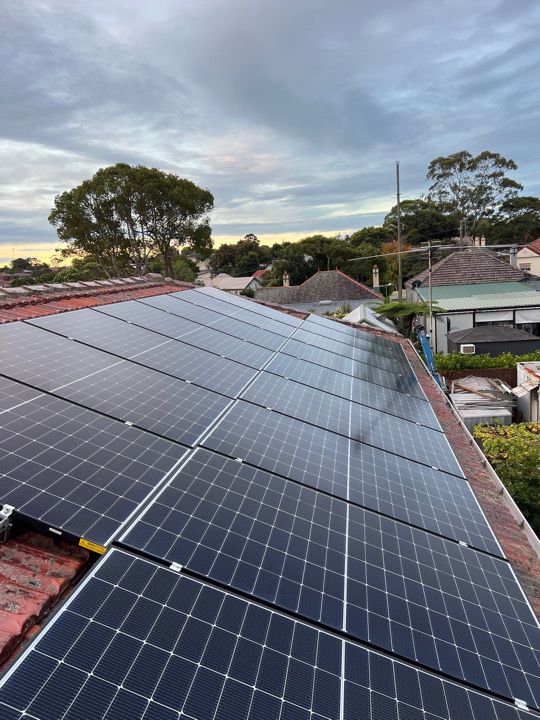 Solar array installed on a tiled Sydney roof at dusk.